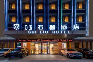 L’extérieur de l’hôtel Shi Li, doté d’une architecture moderne, se distingue par son enseigne lumineuse et une série de balcons.