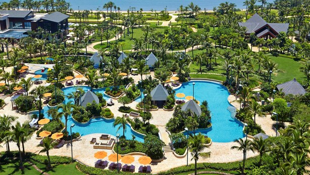 Un resort con varias piscinas, áreas de descanso y acceso directo a la playa.