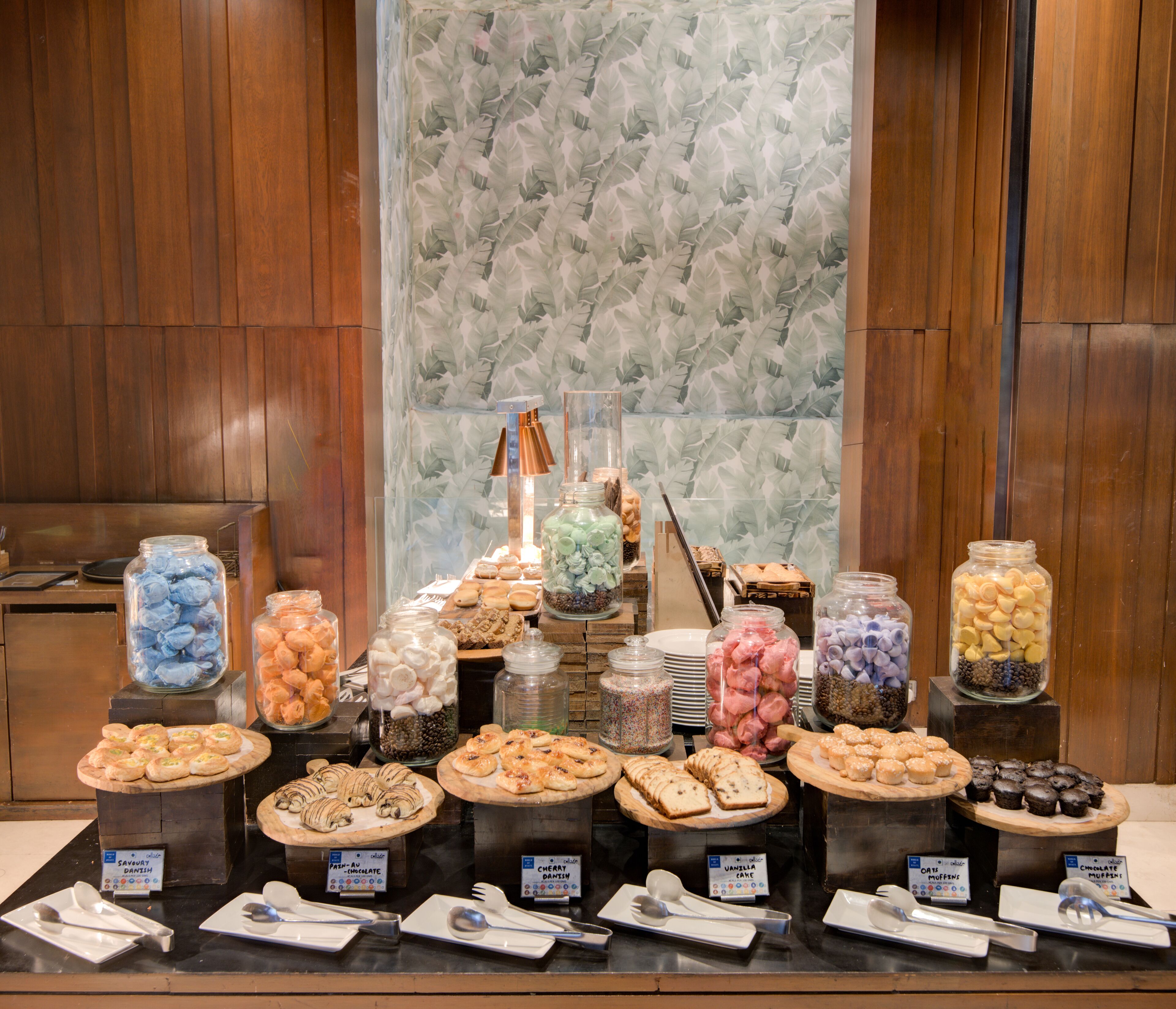 A buffet with various food items and utensils.