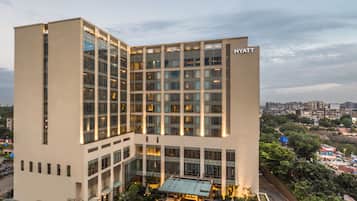 Un hotel moderno con fachada de vidrio, varios pisos y un letrero visible de "HYATT".