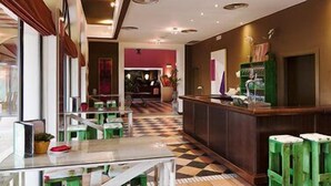 A hotel lobby with a checkered floor, a reception desk, and seating areas. - Hotel Isla Canela Golf (Ayamonte)