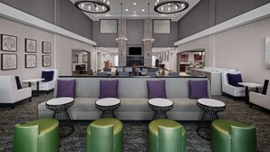 A spacious lobby with a central seating area, a fireplace, and a television. - Homewood Suites by Hilton Carle Place - Garden City, NY (Carle Place)