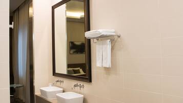 Un baño moderno con dos lavamanos, un espejo grande y una bañera.