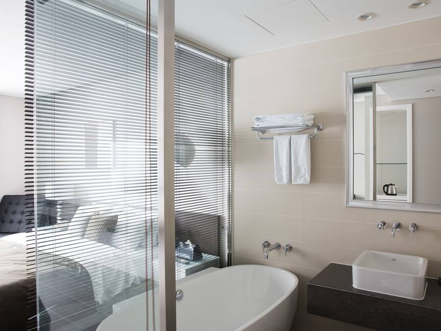 Une salle de bain moderne avec une baignoire sur pieds, un meuble-lavabo et un miroir au-dessus du lavabo.