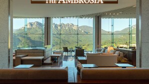 Zona d'estar moderna amb vista a la muntanya, amb seients confortables i una paret de vidre.