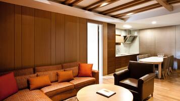 Una sala de estar moderna con sofá, mesa de centro y comedor con sillas y mesa.