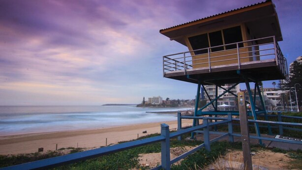A lifeguard tower with a metal railing and a roof, overlooking a beach with a sandy shore and the ocean. - Cronulla Motor Inn (Cronulla)
