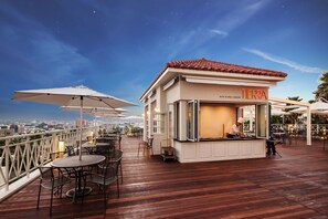 Un restaurante con terraza y vistas a la ciudad.