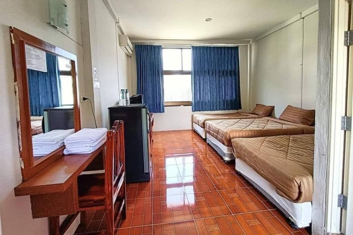 Um quarto com cama, escrivaninha e cadeira.