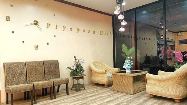 A lobby with wicker furniture, a wall clock, and a large window.