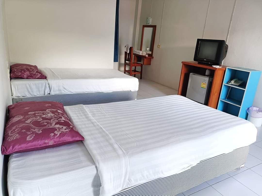 Una habitación de hotel con dos camas, televisión, escritorio y una silla.