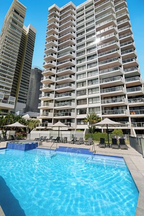 Una piscina al aire libre, tumbonas
