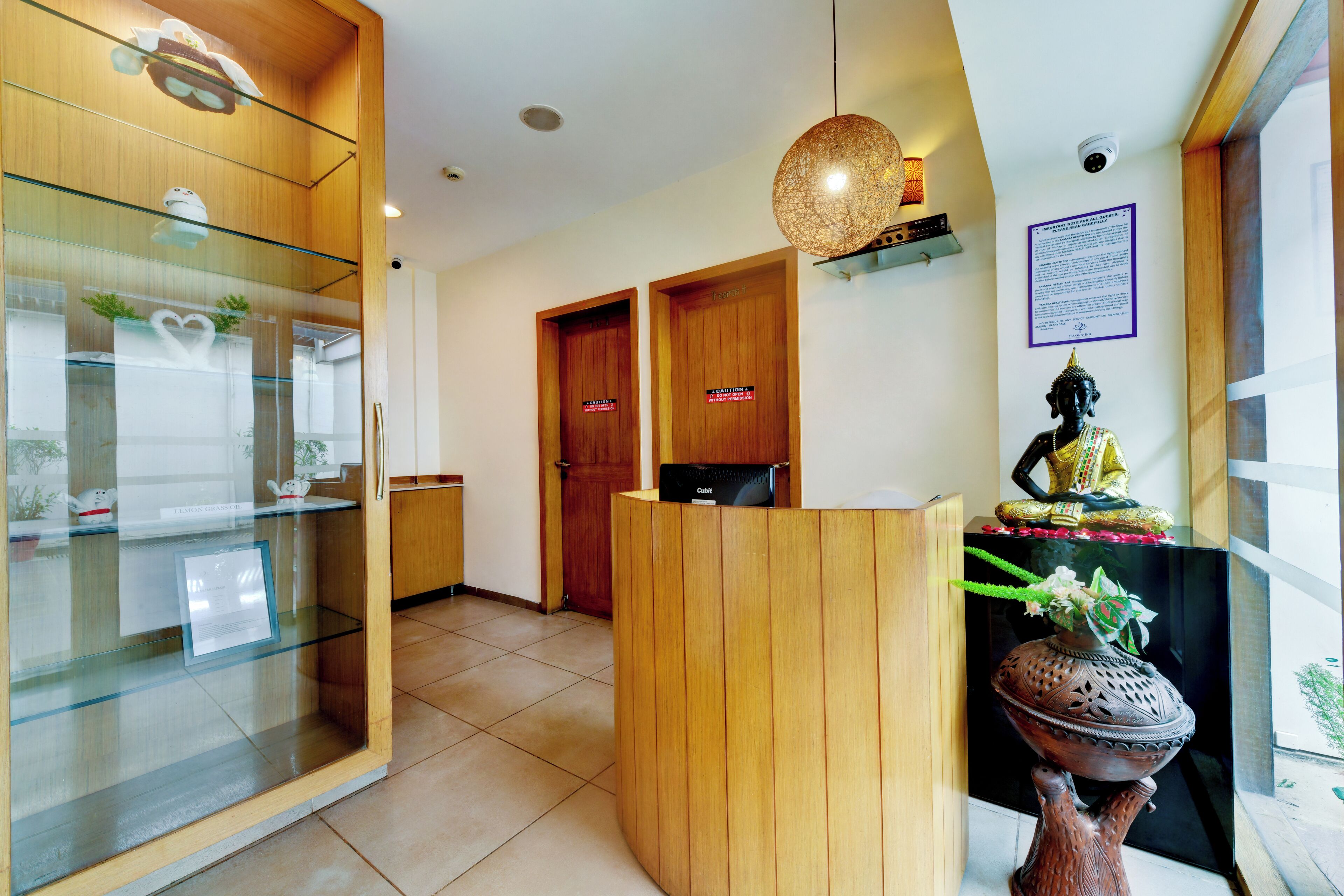 Una zona de recepción con un mostrador de madera, una vitrina de vidrio y una estatua de Buda.