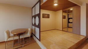 A room with a wooden floor, a round table with chairs, and a sliding door with a mirror. - Sono Belle Byeonsan (Buan)