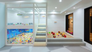 A children's play area with a colorful playroom, a staircase, and a window with toys. - Sono Belle Byeonsan (Buan)
