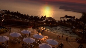 A beachside resort with a pool area, umbrellas, and a sunset view. - Sono Belle Byeonsan (Buan)