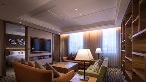 A modern hotel room with a bed, a TV, a sofa, a coffee table, and a lamp. - Green World JianPei (Taipei)