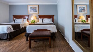 A hotel room with two beds, a bench, and a large mirror. - Del Marqués Hotel and Suites (Guadalajara)