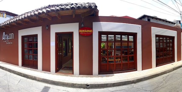 Un edificio con un letrero que dice 'Axkon arte hotel' y 'Mankeme Sabores Colectores Restaurante'.