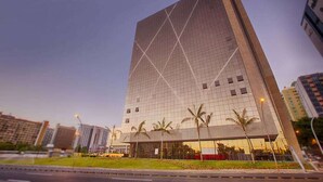 Um edifício moderno alto com fachada em estilo de grade e telhado plano.