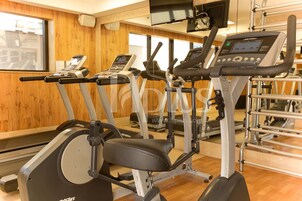 A gym with treadmills, elliptical machines, and weight equipment.