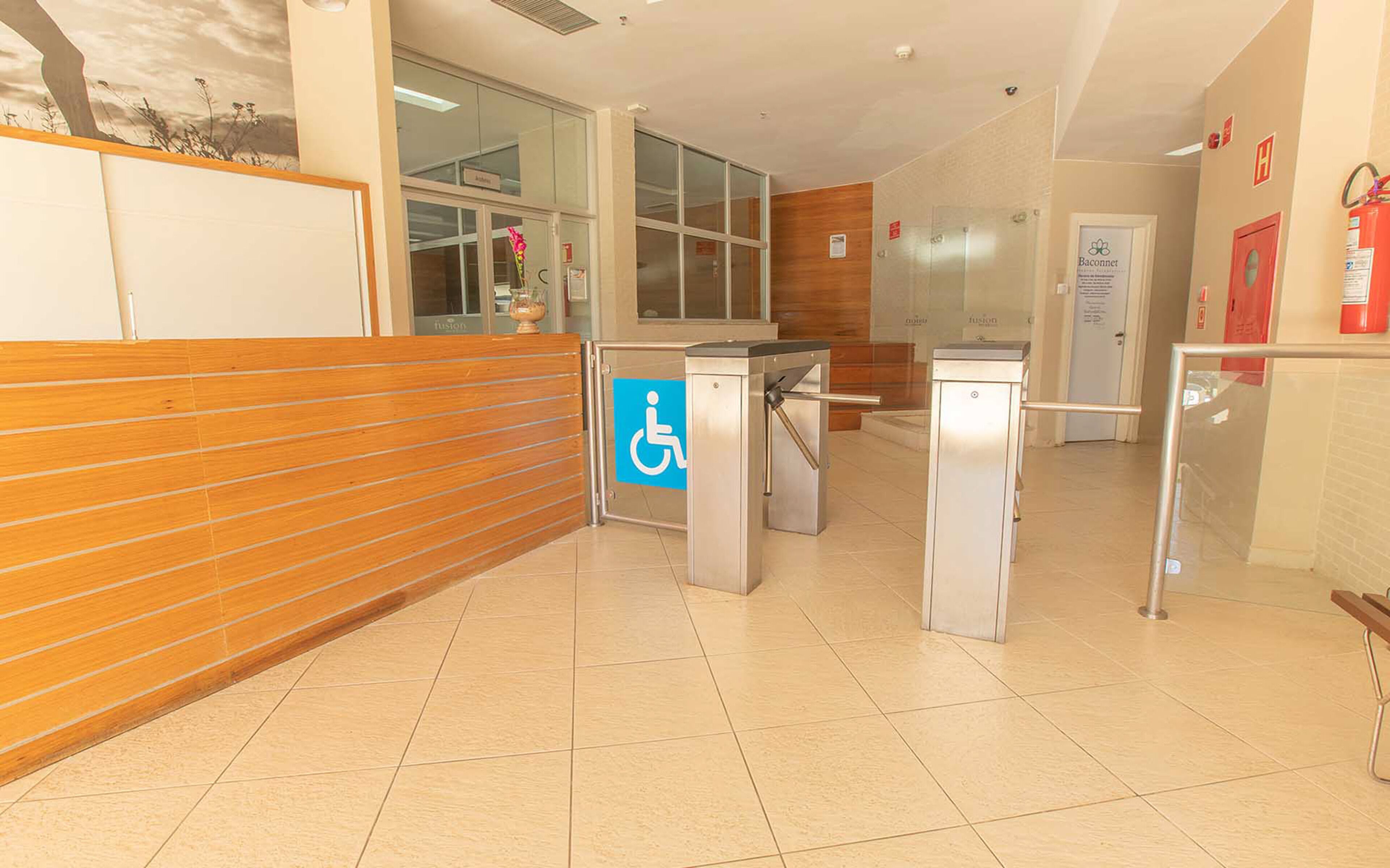 A reception area with a wooden bench, a wheelchair accessible entrance, and a fire extinguisher on the wall.