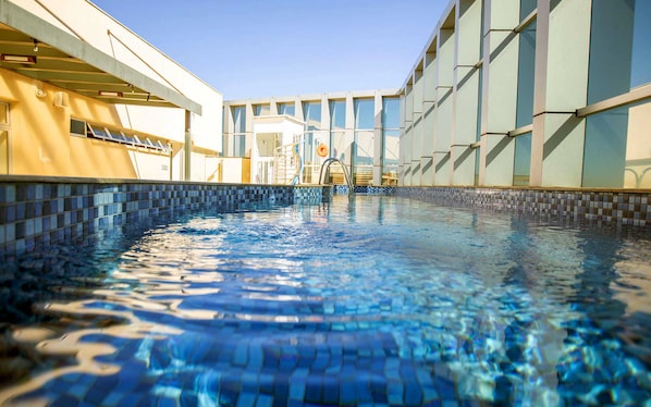 Piscine intérieure, piscine extérieure, parasols, chaises longues