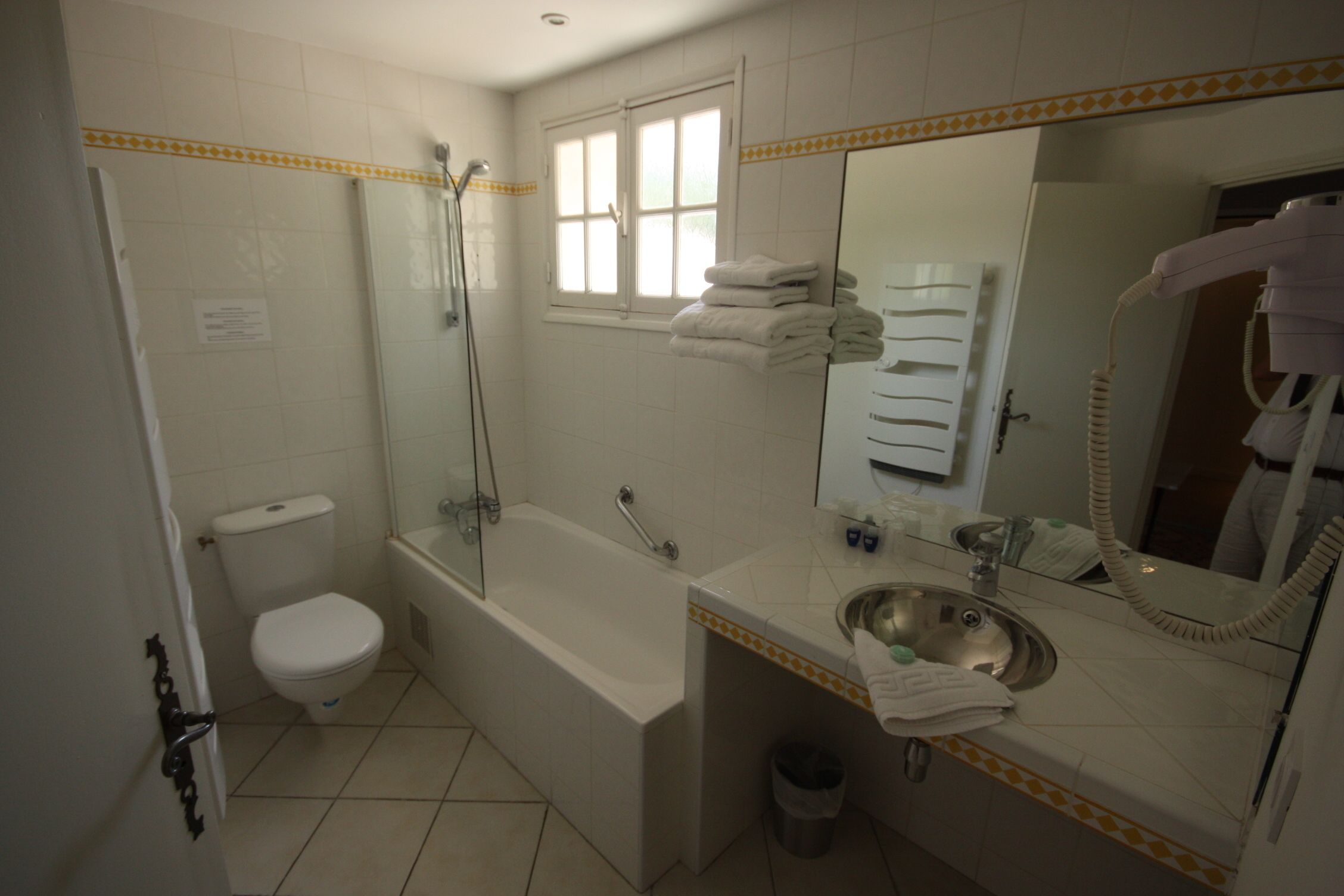 Een badkamer met toilet, bad en wastafel.
