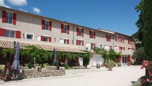 Un hotel con patio, mesas al aire libre y un cartel que indica un restaurante.