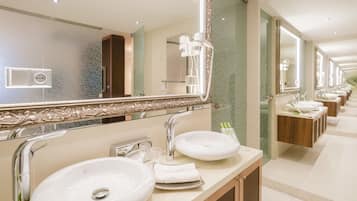 Un baño moderno con dos lavamanos, un espejo grande y un secador de pelo.