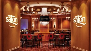 A high-limit salon with a chandelier, multiple bar stools, and a Lauberge sign.