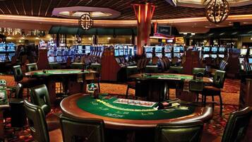 Un casino con múltiples mesas de blackjack, de cartas y máquinas tragamonedas.