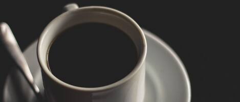 Una taza de café negro sobre un plato.