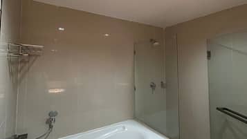Une salle de bain moderne dotée d’une grande baignoire, d’une cabine de douche en verre et d’une douche à l’italienne.