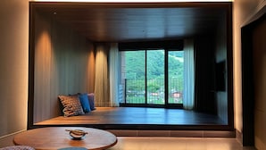 A modern room with a large sliding glass door, a sofa with patterned cushions, and a small round table with a decorative bowl.