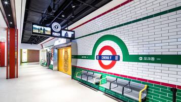 A subway station with a cinema V sign, seating areas, and a digital display.