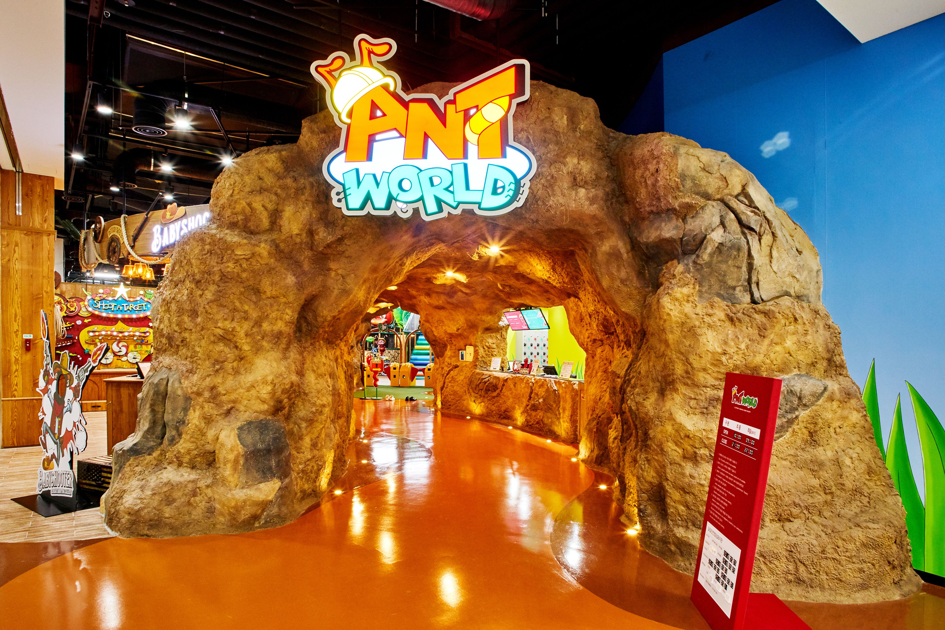 An indoor amusement area with a large rock archway labeled "ANT WORLD".