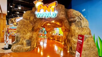 An indoor amusement area with a large rock archway labeled "ANT WORLD".