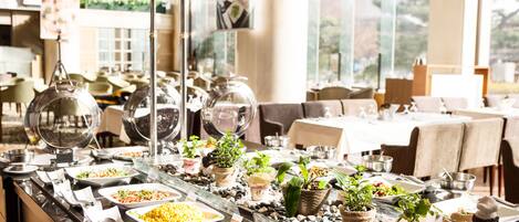 A buffet setup with various food items and a glass display case.