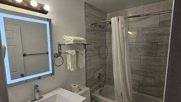 Kombinasi shower/bathtub, perlengkapan mandi gratis,  dan handuk