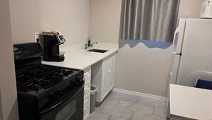 Una cocina funcional con estufa, horno, microondas y pileta.