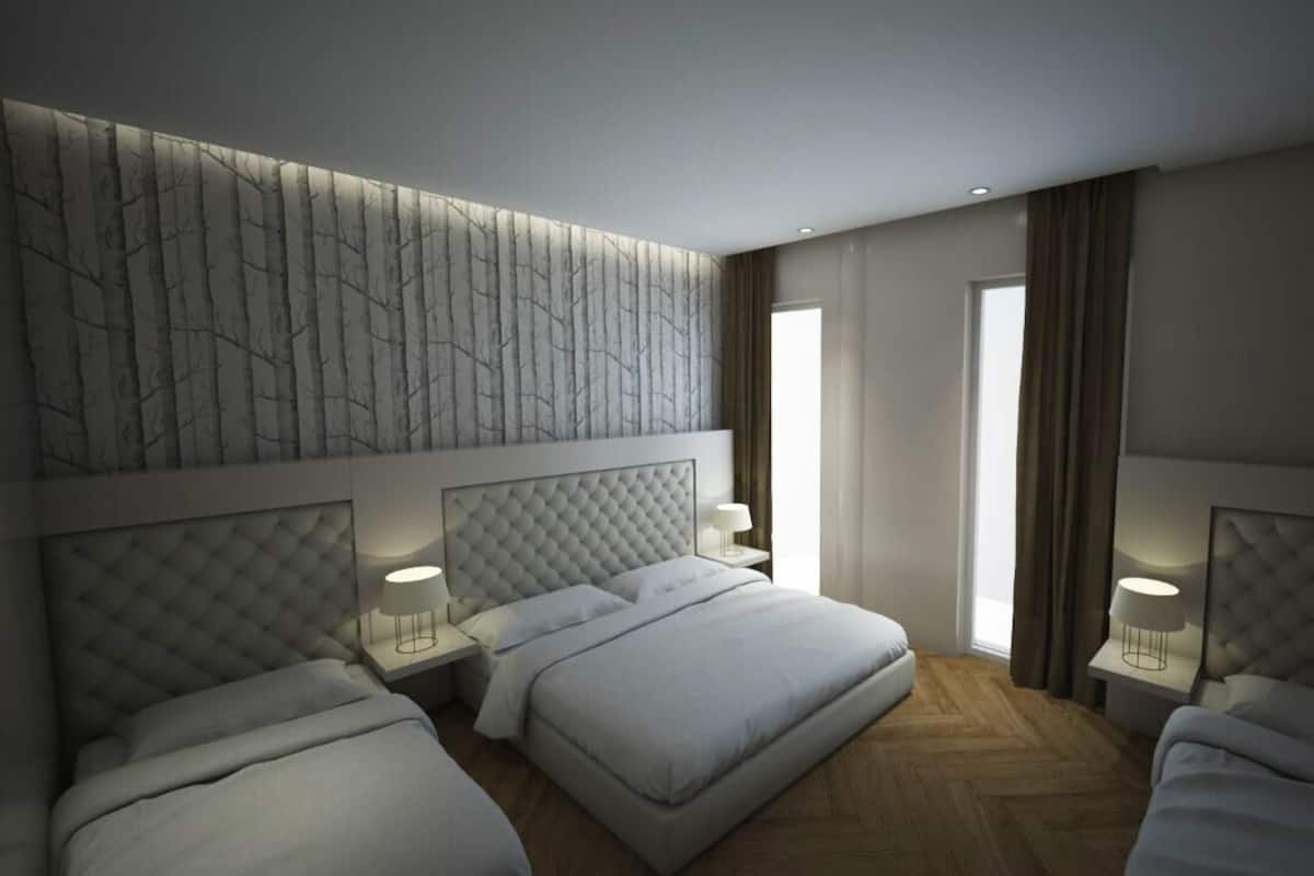 Ein modernes Hotelzimmer mit zwei Betten, einem großen Fenster und einer dekorativen Wandverkleidung.
