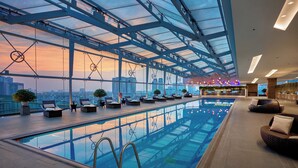 A rooftop swimming pool with lounge chairs and a bar area. - JW Marriott Hotel Hanoi (Hanoi)