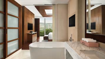 A modern bathroom with a freestanding bathtub, a marble countertop, and a large mirror.