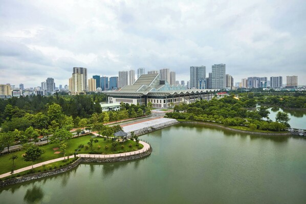 Un edificio grande y moderno con un techo distintivo y un parque circundante con un lago.