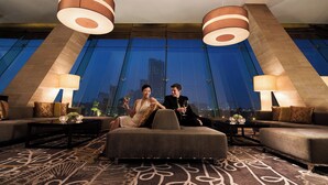 A modern hotel room with a large window, two sofas, a coffee table, and two lamps. - JW Marriott Hotel Hanoi (Hanoi)