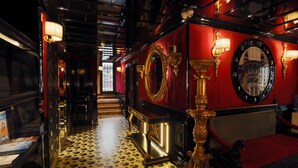 Un interno lussuoso caratterizzato da una palette di colori rosso e nero, specchi decorati e un pavimento a motivi.