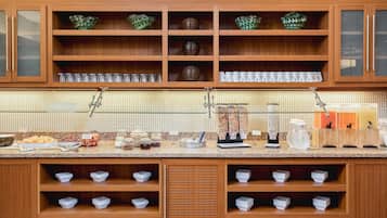 Un'impostazione per buffet con mobili in legno, bicchieri e diverse pietanze.