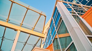 Un edificio moderno con fachada de vidrio y estructura metálica.