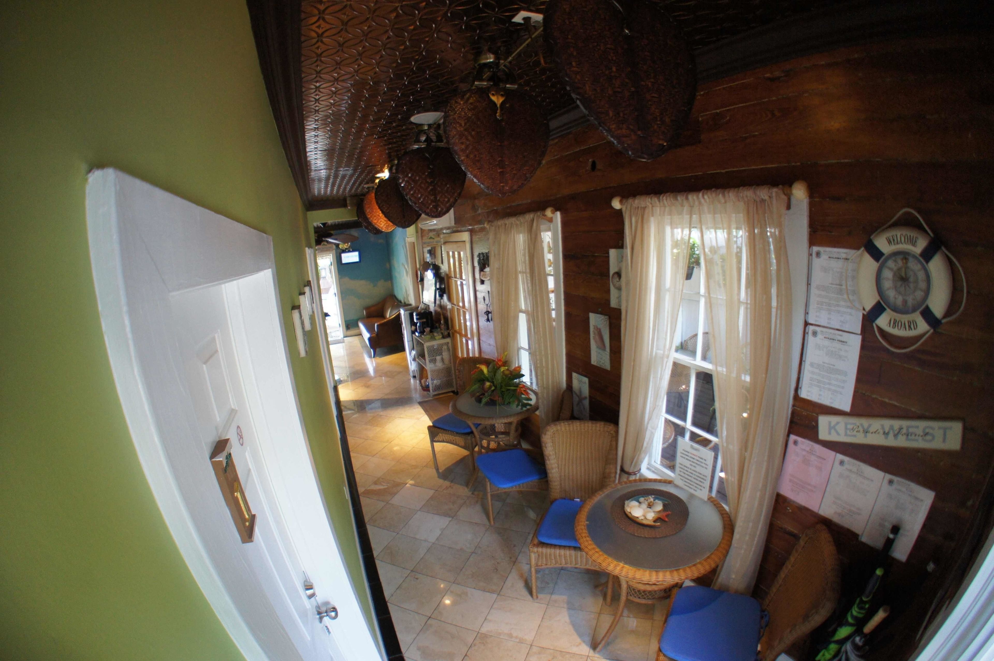 A room with a dining area featuring wicker furniture and a small table with a decorative plate.